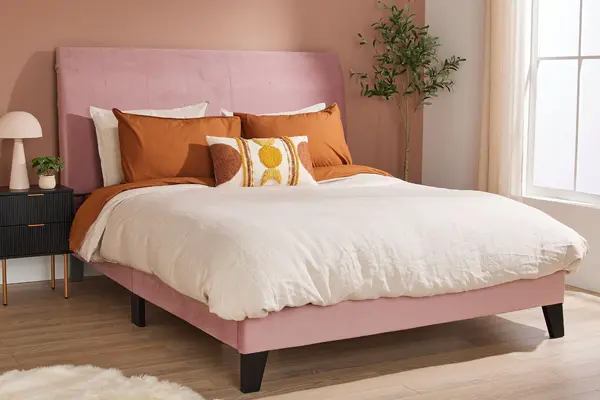 Tufted upholstered bed frame neatly reupholstered and staged in a tidy bedroom